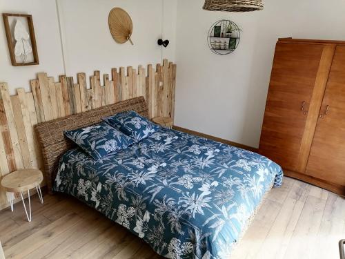 EstaingAux d'Estaing Croisés, Gîte de montagne accessible à tous的一间卧室配有一张带蓝色棉被的床