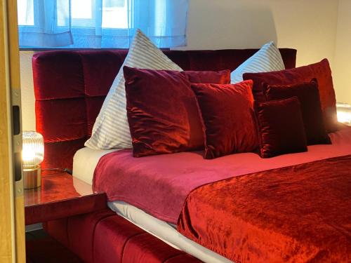 泰特南FeWo Souterrain TT-Bodensee的一张红色的床,上面有很多枕头