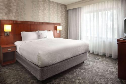 拉古纳山拉古娜希尔斯橙县尔湾万怡酒店的一间卧室设有一张大床和一个大窗户