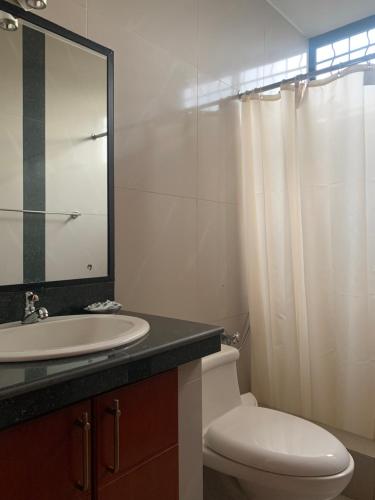 瓜亚基尔Hoteles en Guayaquil - Suites Guayaquil Cerca del Aeropuerto的一间带水槽、卫生间和镜子的浴室