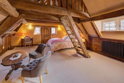 ImbsheimAu Fil du Temps的阁楼卧室设有一张床和一个楼梯