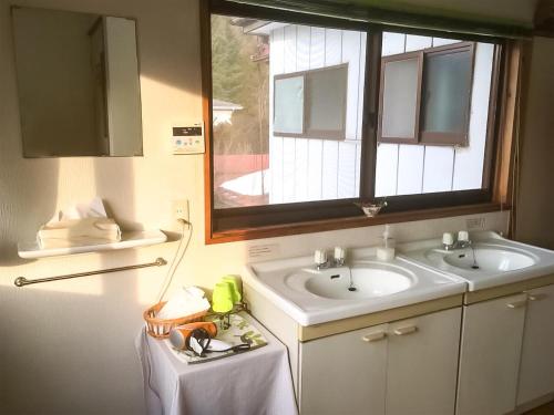 富士河口湖柏屋旅馆的浴室设有两个盥洗盆,上面设有窗户。