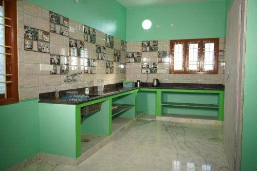 蓬蒂切里SSK HOME STAY的绿色白色的厨房,配有水槽和柜台