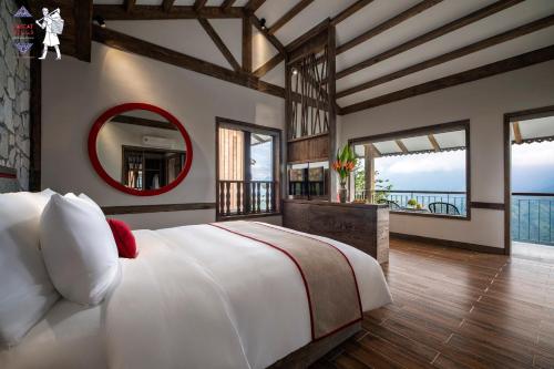 萨帕Sapa Catcat Hills Resort & Spa的一间卧室配有一张大床和镜子