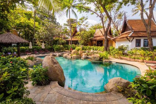 查汶Anavana Beach Resort的一座位于岩石和房屋的花园内的游泳池