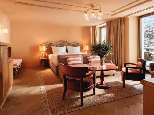 采尔马特BEAUSiTE Zermatt的酒店客房配有一张床铺和一张桌子。