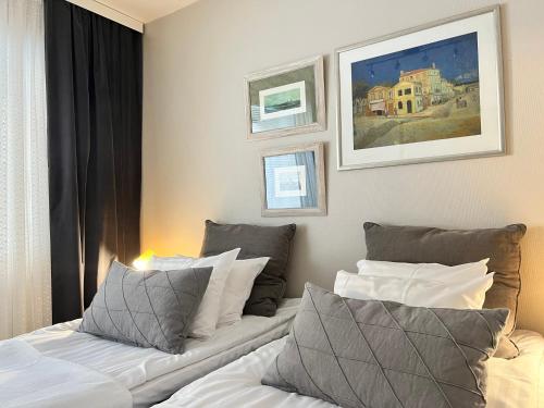 于韦斯屈莱Time Apartments Kärpänkuja的两张床铺,位于酒店客房,墙上挂有绘画作品