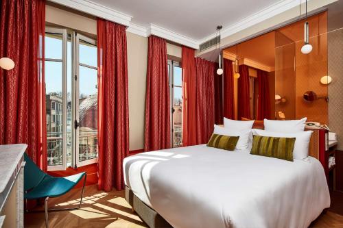 阿维尼翁Hotel De Cambis的卧室配有白色大床和红色窗帘