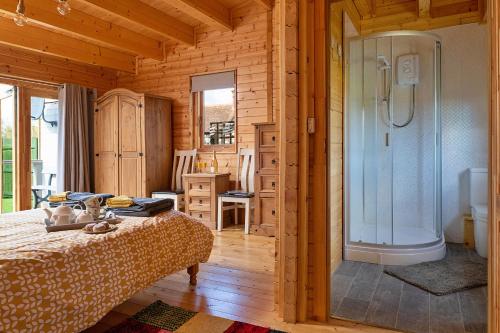 克雷文阿姆斯Finest Retreats - Garden Lodge的一间带淋浴的浴室和一张位于客房内的床