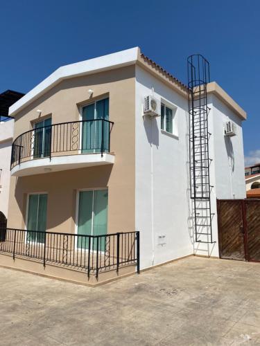 帕福斯Three Bedroom Casa de Paphos的带阳台和蓝天的房子