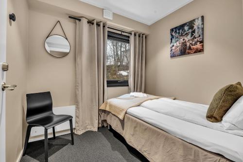 特罗姆瑟Robukta Lodge的卧室配有床、椅子和窗户。