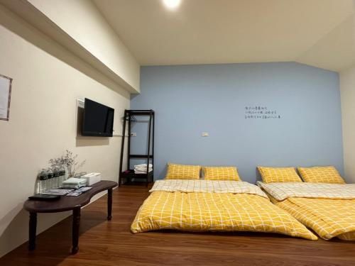 Xingang新港平安民宿的一间卧室设有两张床、一张桌子和一面墙