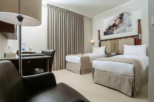 安曼丽塔佳酒店的酒店客房配有两张床和一张书桌