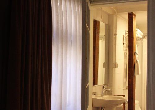 圣地亚哥Hotel Boutique Casa Conde的浴室设有白色的淋浴帘和水槽