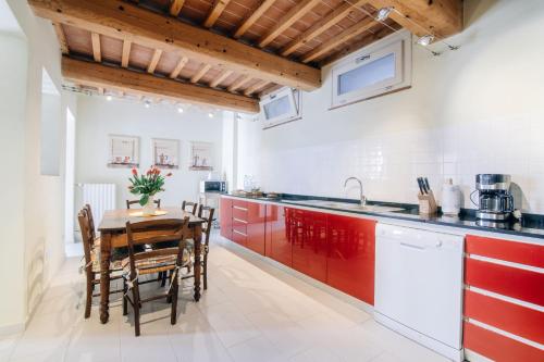 Uzzano伊尔博尔戈德利阿布鲁阿桂米度假屋的厨房配有红色橱柜和桌椅