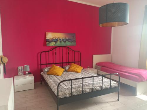 蒙德拉戈内Agata2020的一间卧室配有一张床和粉红色的墙壁