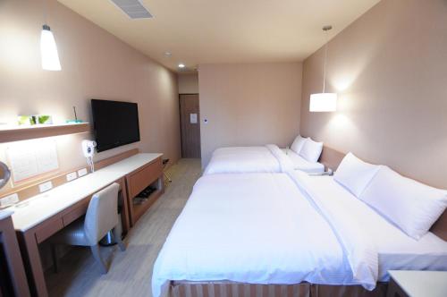 台南康桥商旅 - 台南赤崁楼馆的酒店客房配有两张床和一张书桌