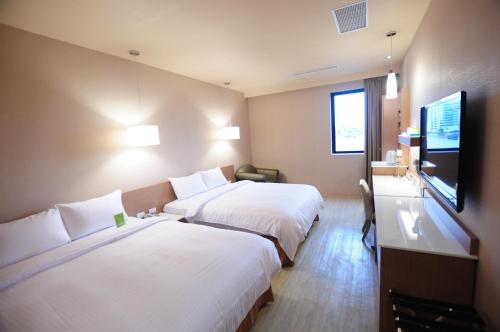 台南康桥商旅 - 台南赤崁楼馆的酒店客房设有两张床和一台平面电视。