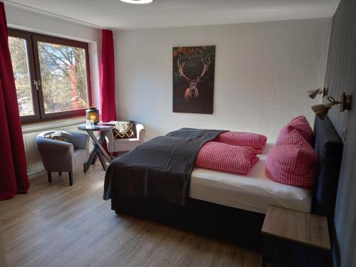 维林根Hotel Engelbracht inklusive MeineCardPlus的一间卧室配有一张带红色枕头的床和一张桌子