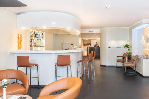 巴特莱辛哈尔加勒里酒店的厨房设有带凳子的酒吧