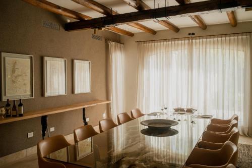 卢汉德库约Susana Balbo Winemaker´s House的一间设有玻璃桌和椅子的用餐室