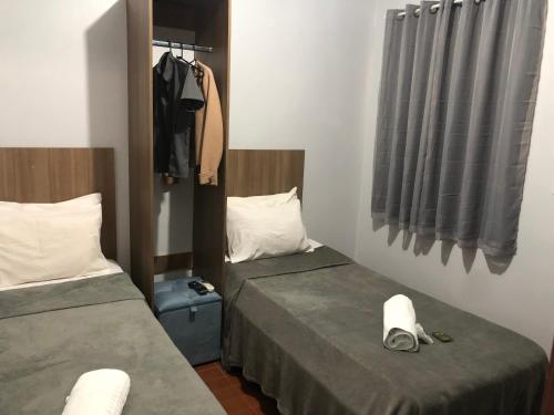 里奥韦尔迪HOTEL RIO VERDE的小型客房配有两张床,