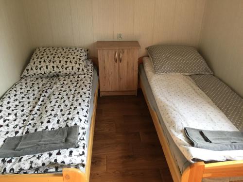 NurDomek przy stawie的配有两张单人床的木柜