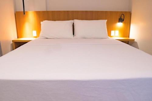 萨利诺波利斯Salinas Premium Resort的一张带两个枕头的大白色床