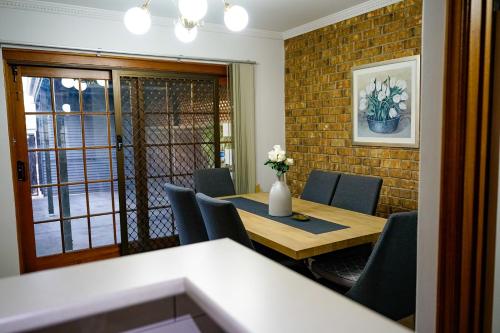 阿德莱德Adelaide Style Accommodation-Getaway in North Adelaide- close to city的一间带木桌和椅子的用餐室