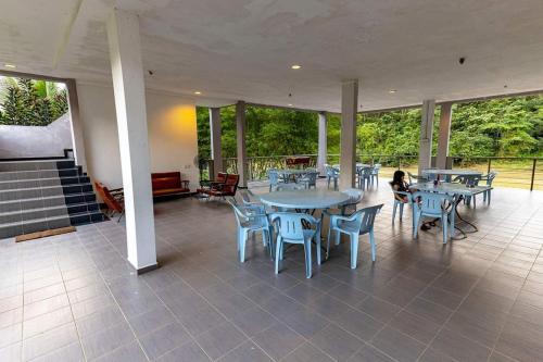 双溪林明RIVERSIDE PALM INN SG LEMBING的大型庭院设有桌椅和窗户。