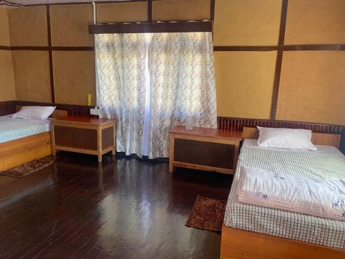 PakhyongKazi Retreat的客房设有两张床和窗户。