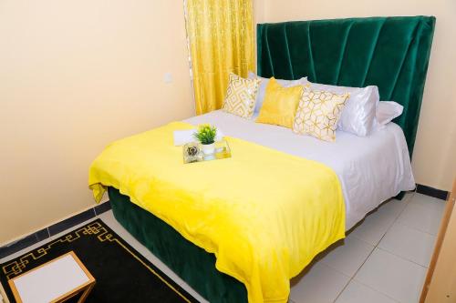 RuiruThe Ivy Suite- one bedroom 3 mins away from Ruiru Rainbow Resort的一间卧室配有一张黄色毯子床