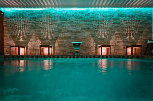 科涅克科涅克中心弗朗索瓦普瑞米尔酒店的一座带砖墙的室内游泳池和一个游泳池