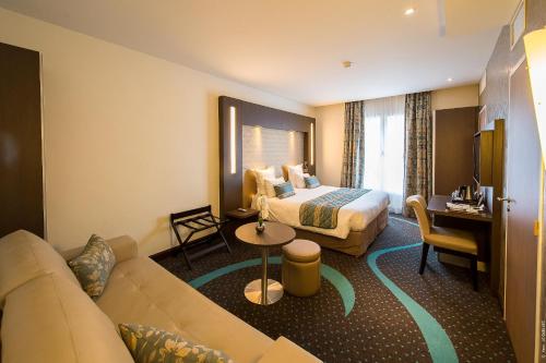 科涅克科涅克中心弗朗索瓦普瑞米尔酒店的酒店客房,配有床和沙发