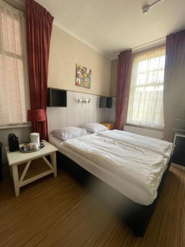 栋堡兹舍尔普旅馆的卧室配有床、桌子和窗户。