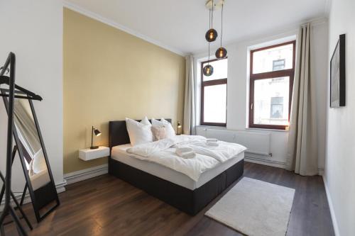 不来梅港Bheaven I Jugendstil Premium Apartment的一间卧室配有一张带白色床单的床和一扇窗户。