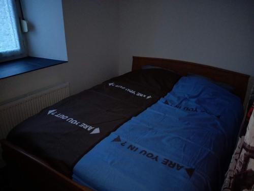 维泰勒Vittel location meublé的一张带蓝色棉被的床,上面写着没有狗睡在床上的话