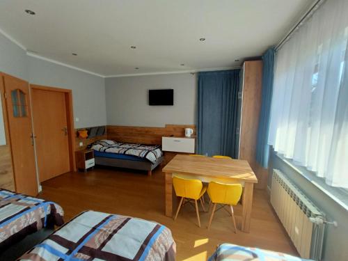 绿山城Noclegi Zielona Góra u Moni的一间带桌子和两张床的房间以及一间卧室
