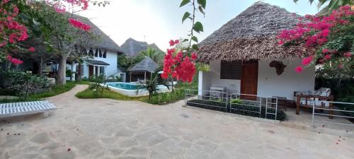 瓦塔穆PWANI HOUSE cottage的一座带游泳池和房子的别墅