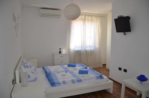 科佩尔Apartments Bertok的一间卧室配有一张带蓝色床单的床和电视。