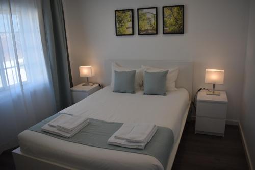 费雷尔Casa do Sapateiro的一间卧室配有一张带两盏灯的大型白色床。
