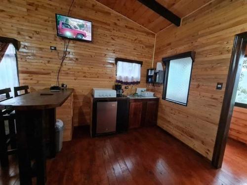 Paso MachoLas Bromelias Lodge的小木屋内的厨房,墙上配有电视