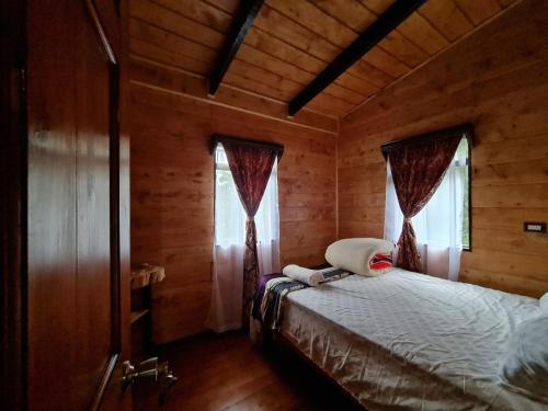 Paso MachoLas Bromelias Lodge的小木屋内一间卧室,配有一张床