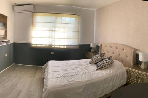 奇特雷PRECIOSO APARTAMENTO DE LUJO AMOBLADO的一间卧室设有一张大床和一个窗户。
