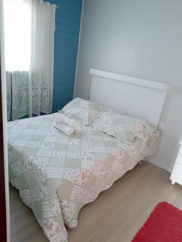 格拉玛多Kitnet Namorados的一间卧室配有床,床上装有被子