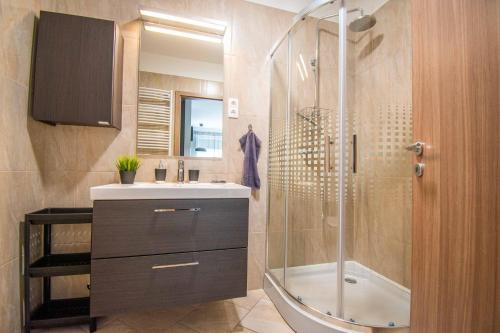 巴拉顿博格拉尔Mediterran Garden Apartman的带淋浴、盥洗盆和浴缸的浴室