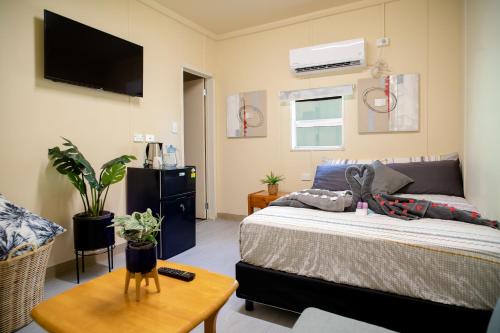莫尔兹比港Green Hills Accommodation Village的卧室配有一张床,墙上配有电视。