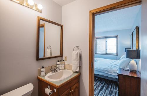 耶洛奈夫Aurora Bayside Inn的一间带水槽和镜子的浴室以及一张床