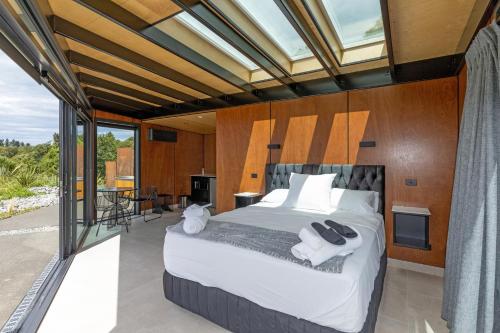 杰拉尔丁Ngā Whare Mānatu的一间带大床的卧室和一个阳台