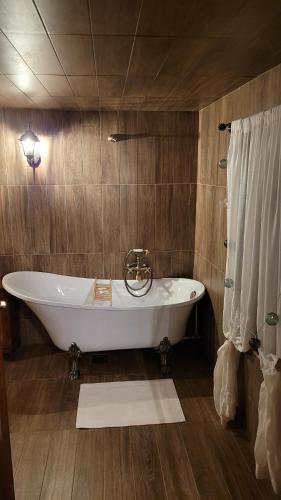 保拉德Mountain cottage的带淋浴的浴室内的白色浴缸